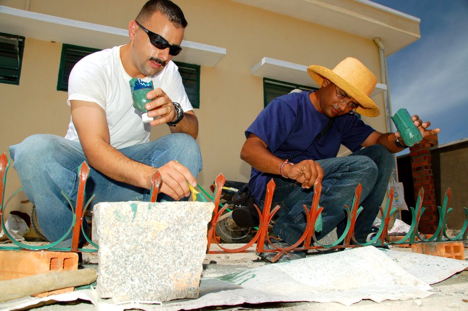 US Navy 080623-N-7498L-117 Master-at-Arms 1st Class Jason Pingeton, left, assigned to the Military Sealift Command hospital ship USNS Mercy (T-AH 19) paints a metal fence railing alongside Lt. Col. Sanje S. Hiremath