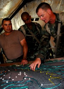 US Navy 080621-N-1120L-013 Builder 1st Class Eric Scott, assigned to Naval Mobile Construction Battalion (NMCB) 7, discusses the Forward Operations Base's security plan with fellow Seabees during the battalion's unit field exer
