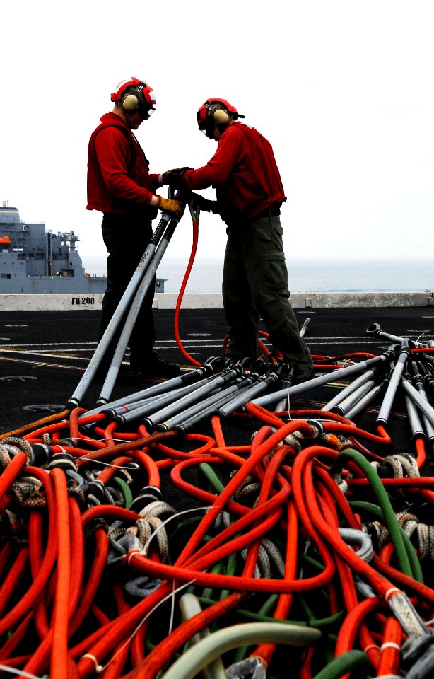 US Navy 080625-N-2610F-065 Aviation Ordanceman 3rd Class Cory Buecheler, left, and Aviation Ordanceman 3rd Class Justin Truitt connect hoisting slings aboard the Nimitz-class aircraft carrier USS John C. Stennis (CVN 74) durin