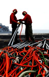 US Navy 080625-N-2610F-065 Aviation Ordanceman 3rd Class Cory Buecheler, left, and Aviation Ordanceman 3rd Class Justin Truitt connect hoisting slings aboard the Nimitz-class aircraft carrier USS John C. Stennis (CVN 74) durin