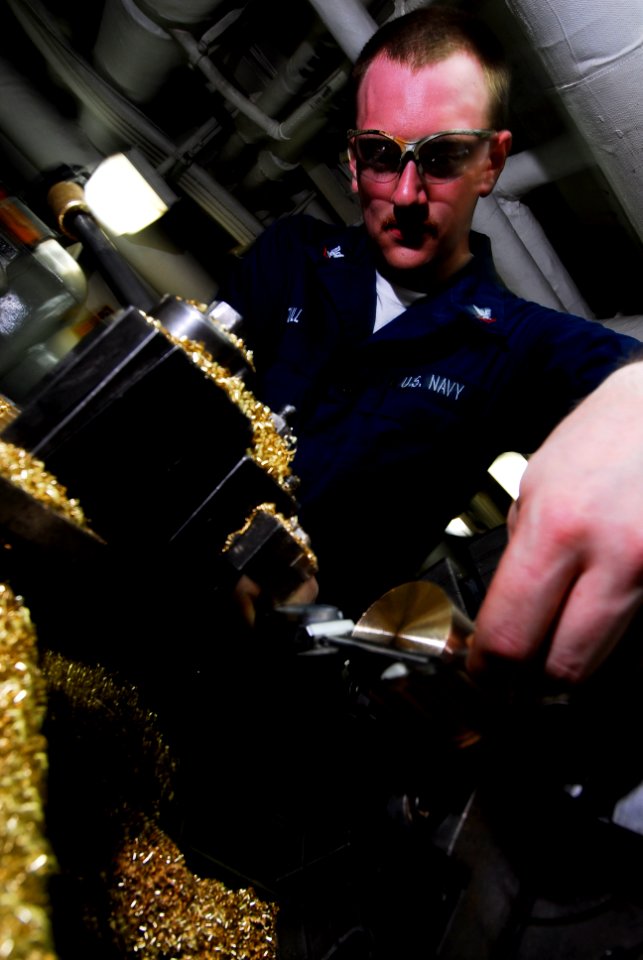 US Navy 080625-N-3946H-036 Machinery Repairman 3rd Class Russell Stull, of Kipton, Ohio, measures the diameter of a brass plug in the machine shop aboard the aircraft carrier USS Kitty Hawk (CV 63)
