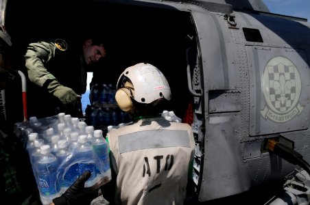 US Navy 080625-N-4009P-944 Chief Aviation Warfare Systems Operator Andrew Smith, of New Castle, Del., helps load water onto an SH-60F Seahawk assigned to the photo