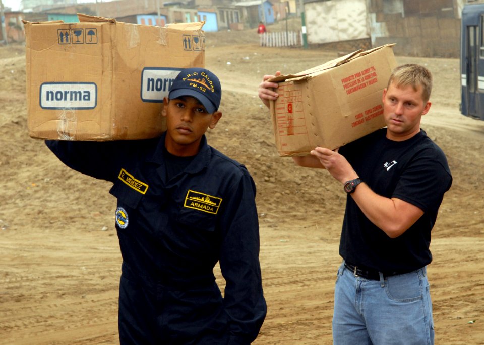US Navy 080622-N-1226D-009 Edgardo Mendez, a Colombian Sailor, and Aviation Machinist's Mate 2nd Class Scott Schinke carry supplies during a community relations project during UNITAS 49-08