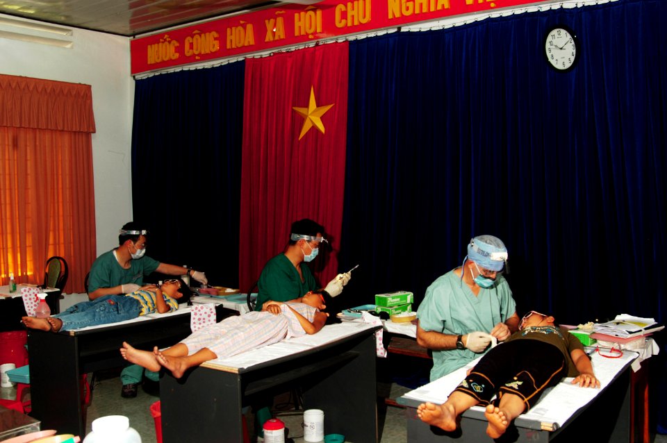 US Navy 080625-N-7498L-131 South Korean Navy Dentist Lt. Michael Sim, left, Canadian Army Dentist Lt. David Lee and East Meets West foundation Dental Director Capt. Charles Craft, perform tooth extractions on Vietnamese childre