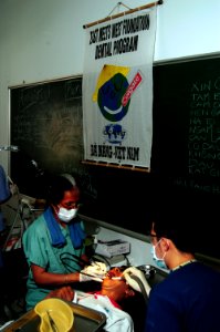 US Navy 080625-N-7498L-110 Cmdr. Monica Rueben, of the U.S. Public Health Service, performs a teeth cleaning on a local Vietnamese patient as part of the Pacific Partnership dental civic action program
