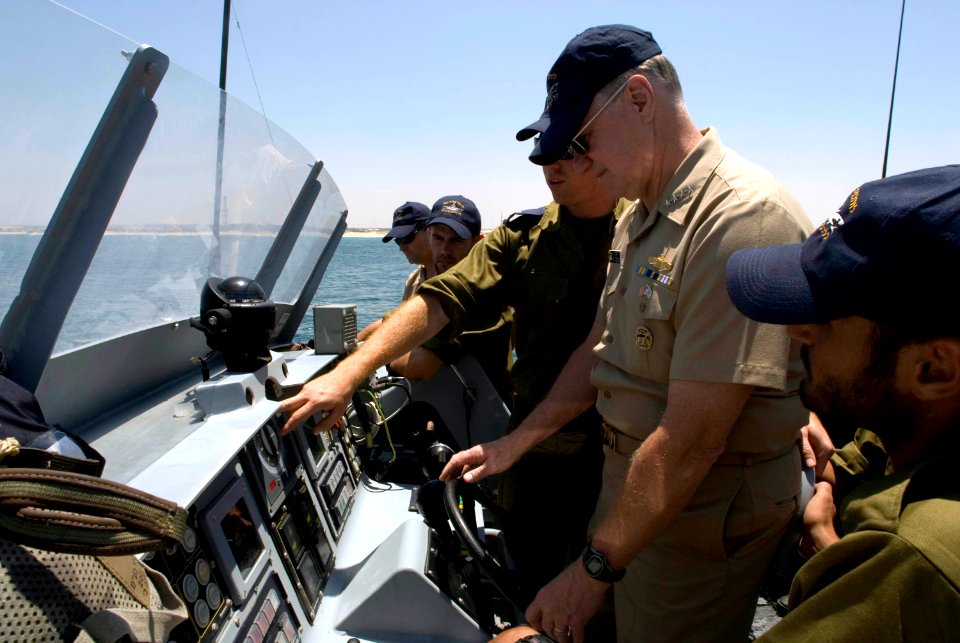 US Navy 080623-N-8273J-215 Chief of Naval Operations (CNO) Adm. Gary Roughead takes the helm aboard the Israel Navy Shaldag patrol craft, while an Israel Navy crew member explains the navigation console
