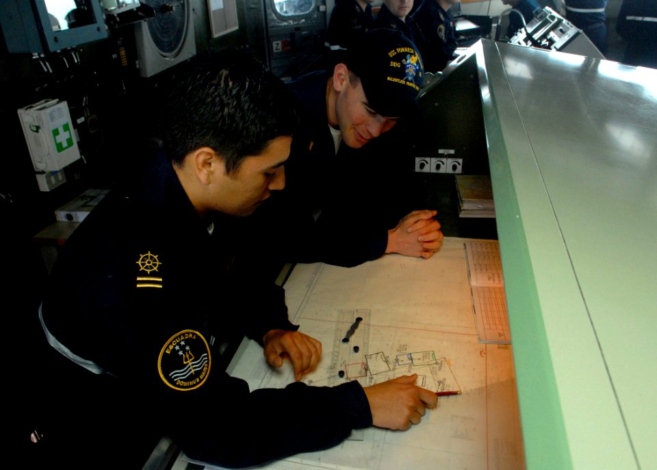 US Navy 080627-N-1226D-154 Chilean sailor Javier Pino Jeria, right, shows U.S. Navy Ens. Shawn Calihan how to plot the ship's location during the Pacific phase of UNITAS 49-08