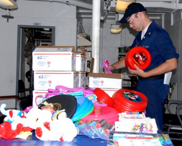 US Navy 080627-G-9409H-442 Petty Officer 3rd Class David Heismann, a quartermaster aboard the amphibious dock landing ship USS Tortuga (LSD 46) sorts through the donations received by his brother