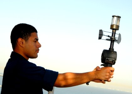 US Navy 080627-N-9604C-031 An aerographer's mate uses a hand held anemometer to check wind direction and speed from the flight deck aboard the amphibious assault ship USS Peleliu (LHA 5)