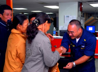 US Navy 080628-N-9689V-005 Ensign Mark Ariizumi, assigned to the Military Sealift Command hospital ship USNS Mercy (T-AH 19), shakes hands with the last Vietnamese patients