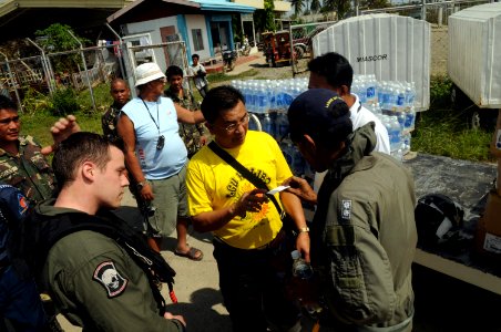 US Navy 080626-N-4009P-262 Raymar Rebaldo, mayor of Kalibo, center, receives food and water delivered from the Nimitz-class aircraft carrier USS Ronald Reagan (CVN 76) photo