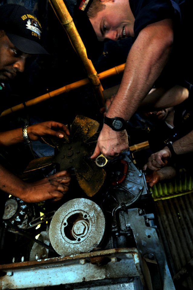 US Navy 080627-N-3659B-452 ) Engineman 2nd Class Shane Whittington, of Quitman, Texas, right, and Electrician's Mate 2nd Class Dante Pine, of Compton, Calif., remove a fuel pump on a generator