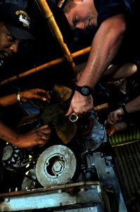 US Navy 080627-N-3659B-452 ) Engineman 2nd Class Shane Whittington, of Quitman, Texas, right, and Electrician's Mate 2nd Class Dante Pine, of Compton, Calif., remove a fuel pump on a generator