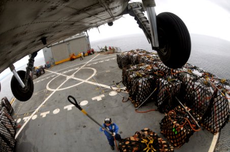 US Navy 080629-N-5961C-013 A HH-60H Seahawk helicopter from Helicopter Anti-Submarine Squadron (HS) 4 lifts another pallet of bottled water from the deck of Military Sealift Command combat stores ship USNS Niagara Falls (T-AFS
