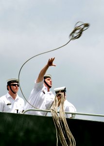 US Navy 080627-N-6674H-146 A Sailor aboard the Australian Navy ship HMAS Anzac (FF 150) throws a line to the Australian amphibious ship HMAS Tolbrook (LSH 50) as they arrive at Naval Station Pearl Harbor for this year's Rim of