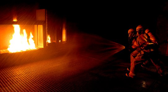 US Navy 080626-N-5345W-103 Fire team members assigned to the aircraft carrier USS Carl Vinson (CVN 70) attempt to put out a controlled fire