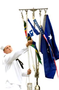 US Navy 080627-N-8467N-003 Electronics Technician 2nd Class Kenneth Walton, assigned to the fast-attack submarine USS Hawaii (SSN 776), hoists the Submarine Squadron 4 pennant photo