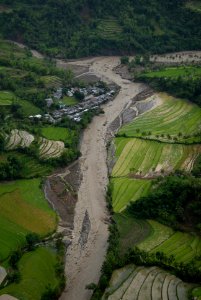 US Navy 080628-N-0640K-259 A flooded river near the city of Alimodian flows dangerously close to buildings photo