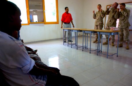 US Navy 080701-F-0986R-031 Children at a local dental clinic in Djibouti watch as Cmdr. Michael Marks, center, Hospital Corpsman 3rd Class Lisandro Zavala, right, and Hospital Corpsman Seaman Sara Brackman demonstrate the prope photo