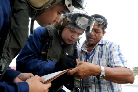 US Navy 080629-N-5961C-003 Chief Storekeeper Jep Rosario, Storekeeper 1st Class Lorenz Partosan and a villager from Kalibo begin to organize how they will receive thousands of liters of bottled water during a vertical replenish