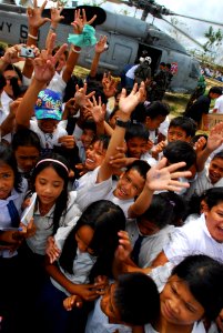 US Navy 080701-N-0640K-305 Residents from the Municipality of Balasan, Philippines wave and cheer after Sailors assigned to the