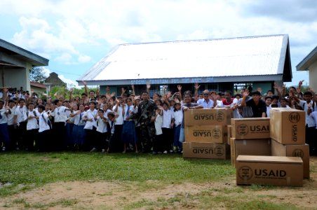 US Navy 080701-N-5961C-012 Children in the Municipality of Balasan waive goodbye to an aircrew from Helicopter Anti-Submarine Squadron (HS) 4 after the delivery of humanitarian supplies to their school photo