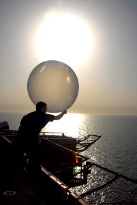 US Navy 080627-N-9604C-025 Aerographer's Mate 1st Class William Palmer releases a weather balloon from the flight deck aboard the amphibious assault ship USS Peleliu (LHA 5)