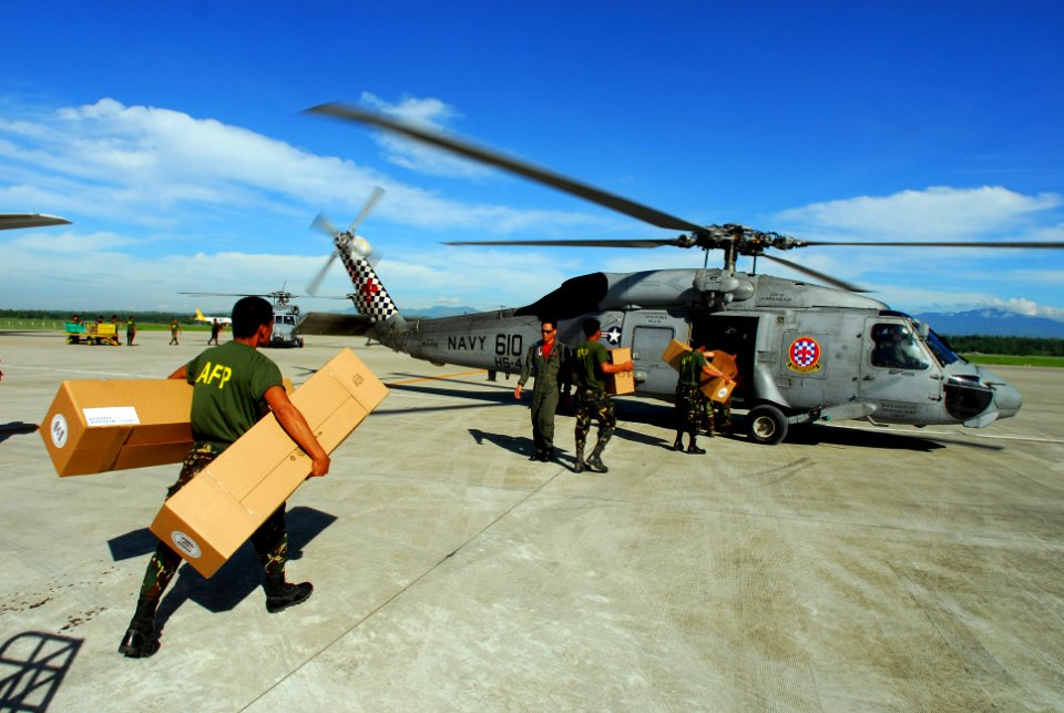 US Navy 080701-N-0640K-046 Soldiers with the Armed Forces of the Philippines carry relief supplies to a waiting SH-60F Seahawk assigned to Helicopter Anti-Submarine Squadron (HS) 4 for delivery to remote locations on the island