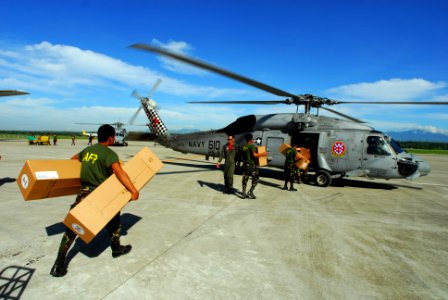 US Navy 080701-N-0640K-046 Soldiers with the Armed Forces of the Philippines carry relief supplies to a waiting SH-60F Seahawk assigned to Helicopter Anti-Submarine Squadron (HS) 4 for delivery to remote locations on the island photo