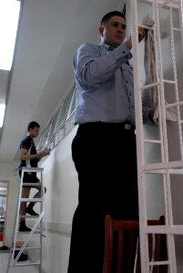 US Navy 080701-G-9409H-647 Information Technician 2nd Class Steven Aguilar, assigned to the frigate USS Jarrett (FFG 33), and 3rd Sgt. Eric Seah, a member of the Republic of Singapore Navy, help clean