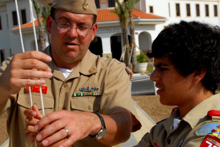 US Navy 080630-N-3289C-061 Senior Chief Operations Specialist Phillip Heldt, assigned to Naval Station Rota, explains how to properly raise the National Ensign to Brennan Outar of Boy Scout Troop 73