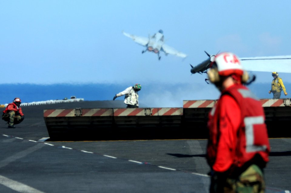 US Navy 080630-N-4009P-635 As the jet blast deflectors retracts, flight deck personnel get ready to hook up the next aircraft on catapult 2