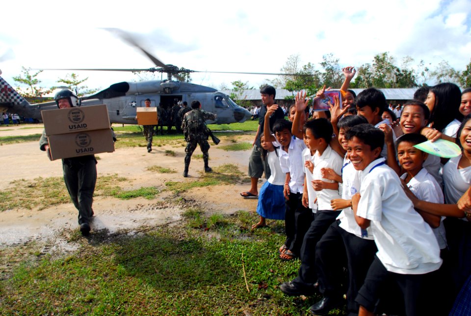US Navy 080701-N-0640K-154 Aviation Warfare Systems Operator 2nd Class Jeremy Thomas, a native of Warren, Ohio, carries supplies to local citizens of Balasan, Philippines