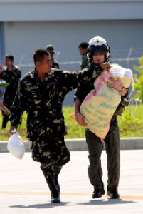 US Navy 080630-N-5961C-009 Lt. Brandon Sheets, right, carries a 100-pound sack of rice while a soldier from the Armed Forces of the Philippines lends a hand trying to keep the bag closed