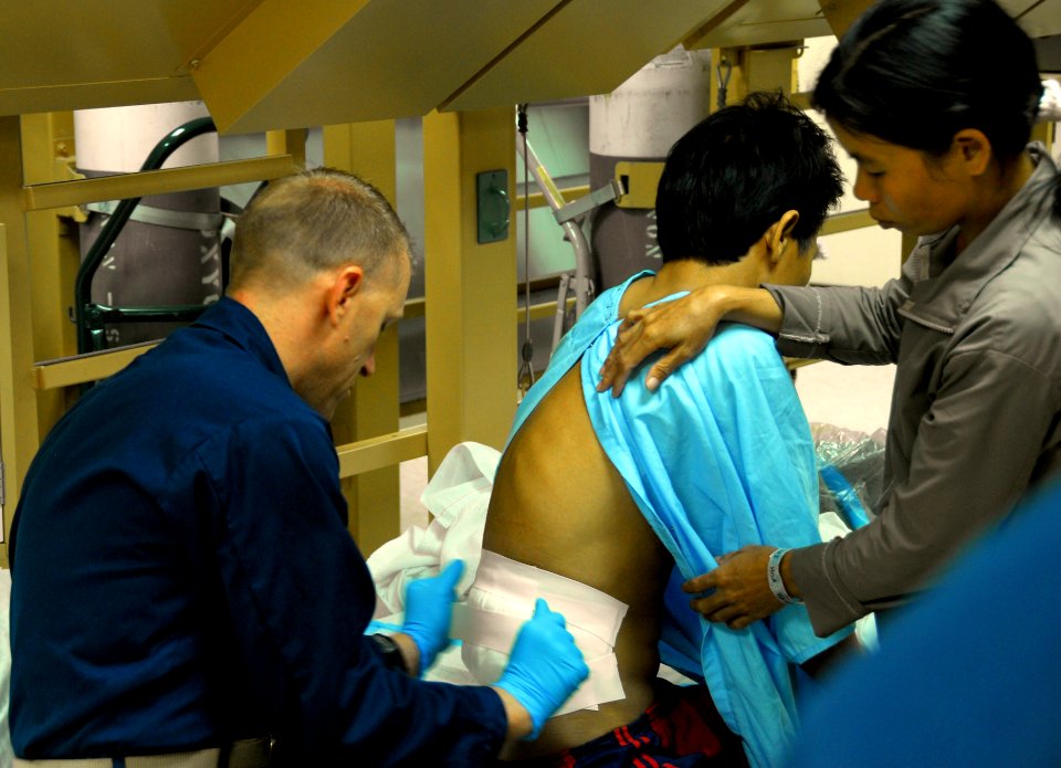 US Navy 080628-N-9689V-007 Lt. Todd Hlavac, a staff nurse assigned to the Military Sealift Command hospital ship USNS Mercy (T-AH 19), changes the dressing for a Vietnamese patient before his discharge to a local hospital