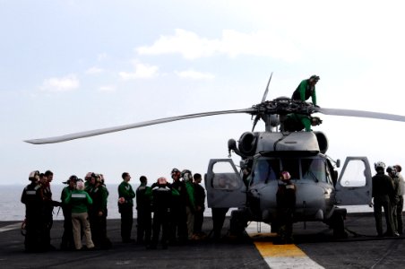 US Navy 080630-N-3659B-086 Flight deck personnel stand by as last minute maintenance is performed on an SH-60F Seahawk