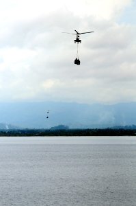 US Navy 080629-N-5961C-006 Super PUMA helicopters fly much needed bottled water to Kalibo, Republic of the Philippines from the deck of the Military Sealift Command combat stores ship USNS Niagara Falls (T-AFS 3)