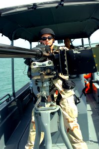 US Navy 080705-A-1912B-010 Coast Guard Machinery Technician 3rd Class Robert Berg, assigned to Coast Guard Port Security Unit (PSU) 307, mans the bow gun in a transportable port security boat