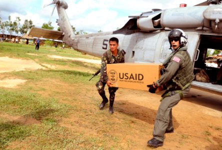 US Navy 080701-N-5961C-011 Aviation Warfare Systems Operator 2nd Class Anthony Chavez, a native of San Bernardino, Calif., works with a soldier from the Armed forces of the Philippines to move relief supplies to a school on the photo