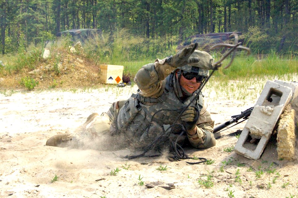 US Navy 080702-A-4429M-009 teven Sublett, assigned to Navy Bravo Company aboard Army base Fort Dix, throws a hook to check for explosives during training at Range 26