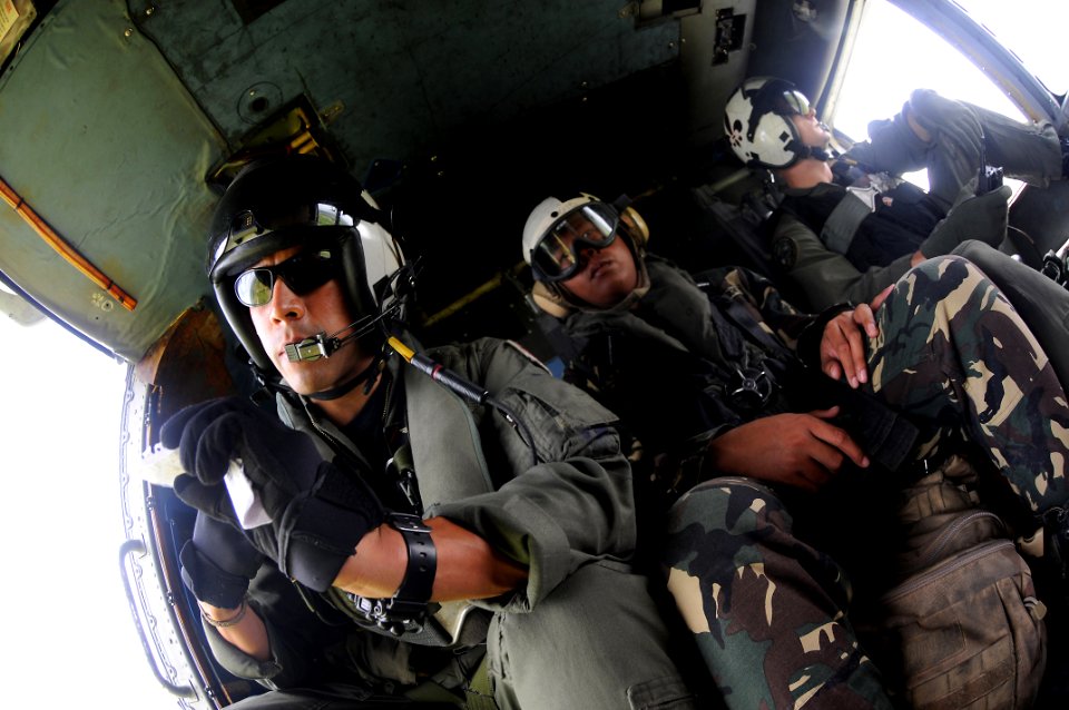 US Navy 080701-N-5961C-015 A service member with the Armed Forces of the Philippines sits with a U.S. Navy aircrew in the aft station of an SH-60F Seahawk assigned Helicopter Anti-Submarine Squadron (HS) 4 during a humanitarian
