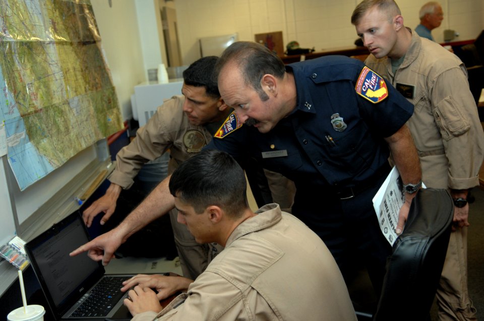 US Navy 080630-F-1689G-006 Marines assigned to Marine Medium Helicopter Training Squadron (HMMT) 164 and Marine Medium Helicopter Squadron (HMM) 268 review flight plans with Fire Chief Jim Gonzalez