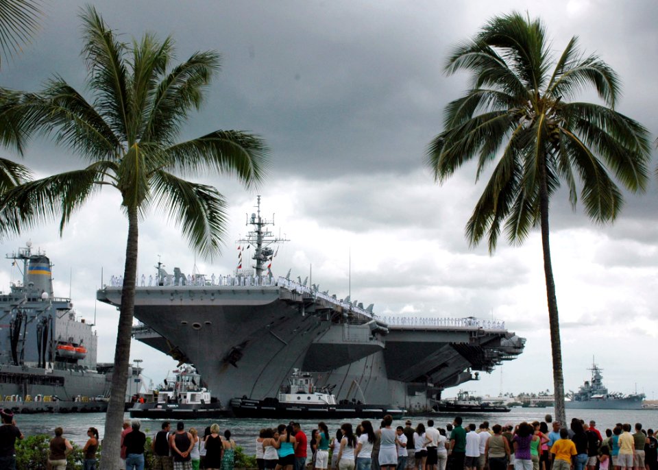 US Navy 080701-N-9076B-006 Visitors to Naval Station Pearl Harbor look on as the aircraft carrier USS Kitty Hawk (CV 63) ties up at pier