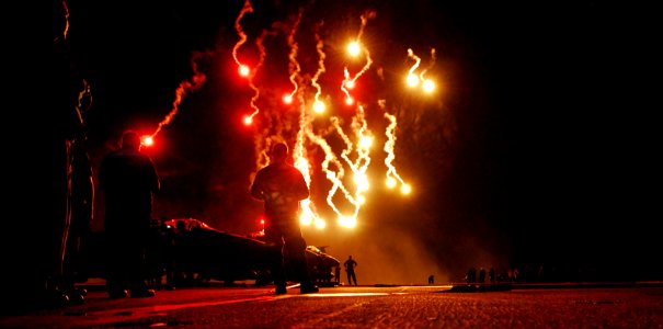 US Navy 080704-N-0640K-271 Sailors watch flares light up the sky during a Navy-style fireworks display on the flight deck of the Nimitz-class aircraft carrier USS Ronald Reagan (CVN 76) photo