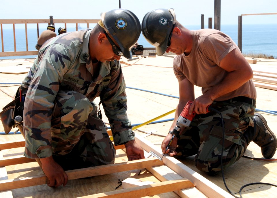 US Navy 080705-N-1424C-902 Construction Electrician 1st Class Samuel Roman and Builder 3rd Class Christopher Eyles, assigned to Amphibious Construction Battalion (ACB) 1 rebuild the deck of a platform overlooking Red Beach