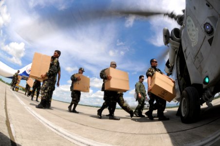 US Navy 080701-N-5961C-013 Soldiers with the Armed Forces of the Philippines aircrewmen assigned to Helicopter Anti-Submarine Squadron (HS) 4 load relief supplies onto an SH-60F Seahawk to air-lift to a remote location photo
