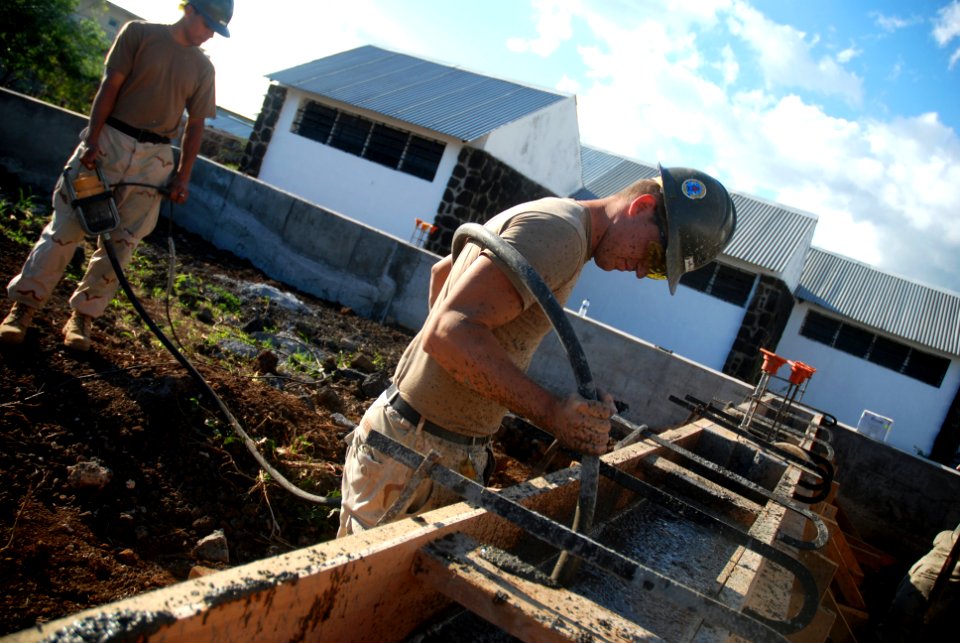 US Navy 080707-N-3674H-198 Steelworker 3rd Class Timothy Hemphill, assigned to Naval Mobile Construction Battalion (NMCB) 74, removes air bubbles from the form for a concrete foundation