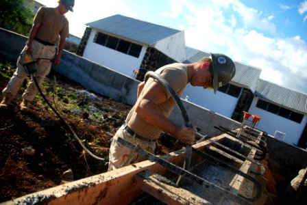 US Navy 080707-N-3674H-198 Steelworker 3rd Class Timothy Hemphill, assigned to Naval Mobile Construction Battalion (NMCB) 74, removes air bubbles from the form for a concrete foundation