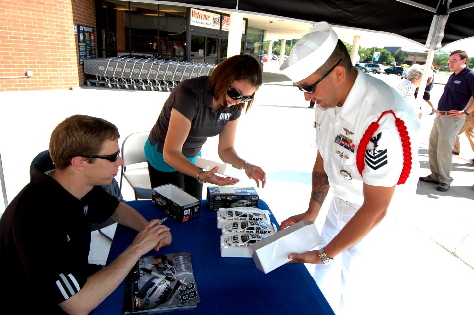 US Navy 080710-N-8848T-016 Aviation Maintenance Administrationman Shon Nuanez gives four die-cast No. 88 Navy Accelerate Your Life models to NASCAR Nationwide Series driver Brad Keselowski to autograph
