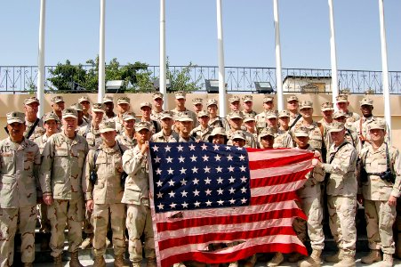 US Navy 080704-F-7045D-002 Sailors from Combined Security Transition Command-Afghanistan hold a vintage American flag with 48 stars, which was flown over Camp Eggers in Kabul, Afghanistan, to commemorate Fourth of July celebrat photo